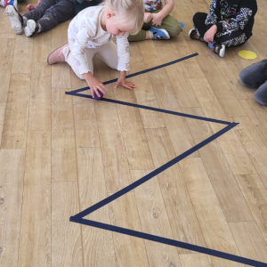 Dziewczynka turlająca piłeczkę po torze.