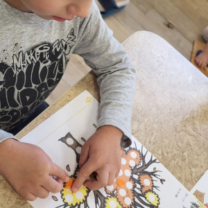Chłopiec wykonuje pracę plastyczną.