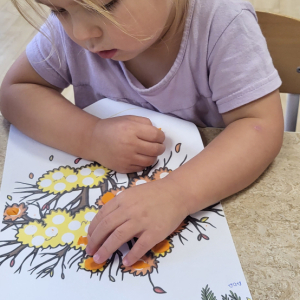 Dziewczynka wykonuje pracę plastyczną.