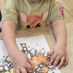 Dziewczynka wykonuje pracę plastyczną.