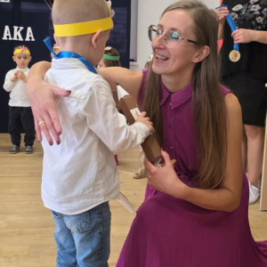 Chłopiec odbierający gratulacje od nauczycielki