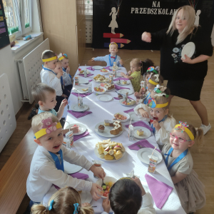 Dzieci siedzące przy stole podczas poczęstunku