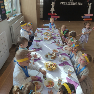 Dzieci siedzące przy stole podczas poczęstunku