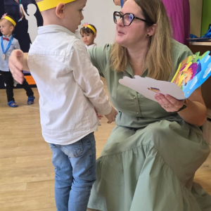 Chłopiec odbierający gratulacje od nauczycielki