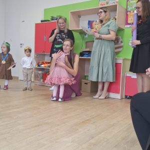 Dziewczynka odbierająca gratulacje od nauczycielki to muszę