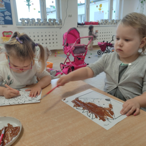 Dzieci malujące jeża na kartce papieru