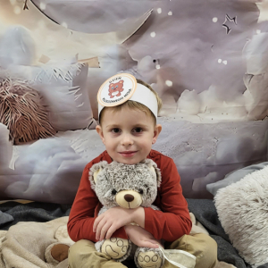 Chłopiec pozujący na przygotowanej ściance fotograficznej.