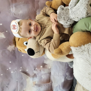 Chłopiec pozujący na przygotowanej ściance fotograficznej.