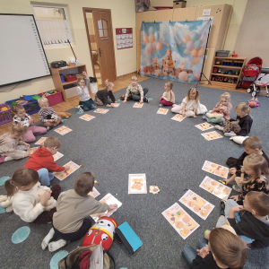 Dzieci siedzą w kole i graja w misiowe Bingo