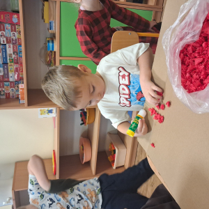 Dziecko wykleja angielska budkę telefoniczną kolorową bibułą