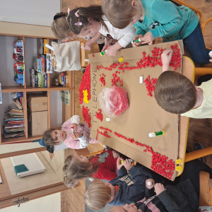 Dziecko wykleja angielska budkę telefoniczną kolorową bibułą