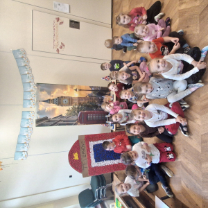 Dzieci siedzą na tle wystawy dotyczącej Londynu