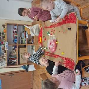 Dziecko wykleja angielska budkę telefoniczną kolorową bibułą