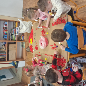 Dziecko wykleja angielska budkę telefoniczną kolorową bibułą