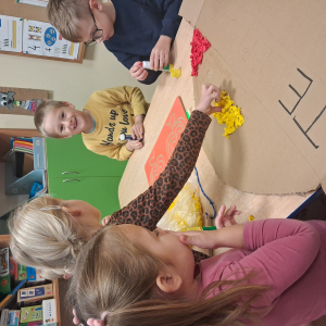 Dziecko wykleja angielska budkę telefoniczną kolorową bibułą