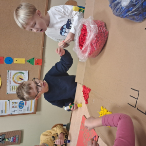 Dziecko wykleja angielska budkę telefoniczną kolorową bibułą