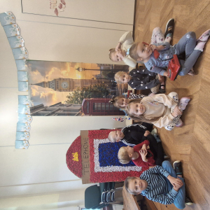 Dzieci siedzą na tle wystawy o Londynie