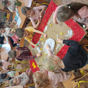 Dziecko wykleja angielska budkę telefoniczną kolorową bibułą