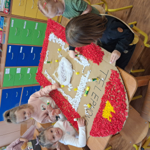 Dziecko wykleja angielska budkę telefoniczną kolorową bibułą