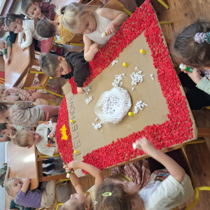 Dziecko wykleja angielska budkę telefoniczną kolorową bibułą