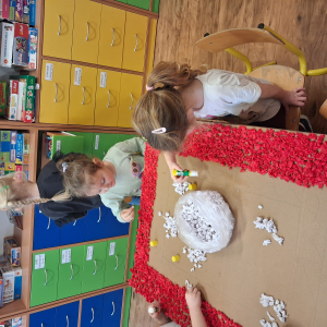 Dziecko wykleja angielska budkę telefoniczną kolorową bibułą