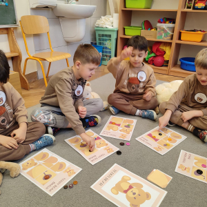 Dzieci siedzą w kole grają w misiowe Bingo