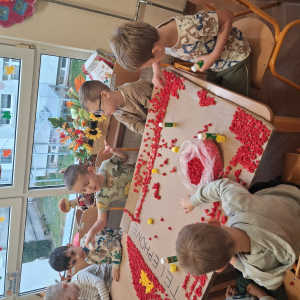 Dziecko wykleja angielska budkę telefoniczną kolorową bibułą