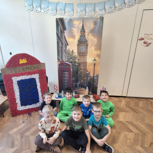 Dzieci siedzą na tle wystawy dotyczącej Londynu