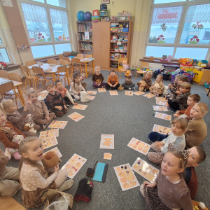 Dzieci siedzą w kole i graja w misiowe Bingo