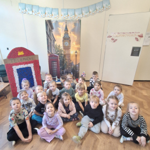 Dzieci siedzą na tle wystawy dotyczącej Londynu