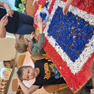 Dziecko wykleja angielska budkę telefoniczną kolorową bibułą