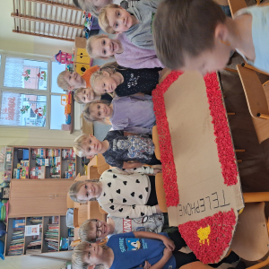 Dziecko wykleja angielska budkę telefoniczną kolorową bibułą