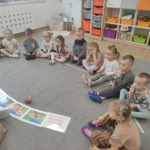 dzieci siedzą na dywanie i słuchają bajki o jeżyku