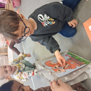 dziecko karmi wiewiórkę obrazkami przedstawiającymi słownictwo jesienne