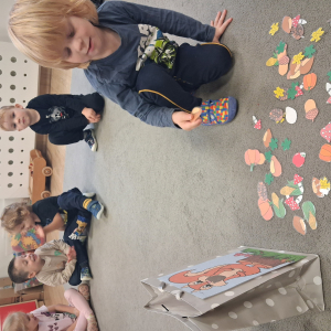 Dziecko trzyma w dłoni obrazek o tematyce jesiennej