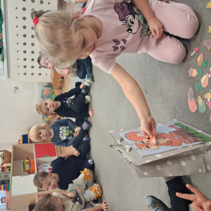 Dziecko trzyma w dłoni obrazek o tematyce jesiennej