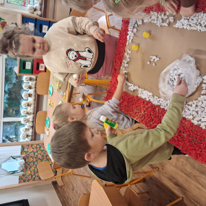 Dziecko wykleja angielska budkę telefoniczną kolorową bibułą