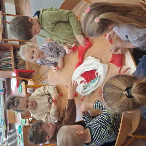 Dziecko wykleja angielska budkę telefoniczną kolorową bibułą