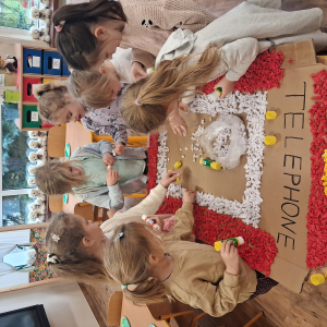 Dziecko wykleja angielska budkę telefoniczną kolorową bibułą