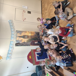 Dzieci siedzą na tle wystawy dotyczącej Londynu