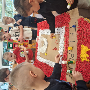 Dziecko wykleja angielska budkę telefoniczną kolorową bibułą