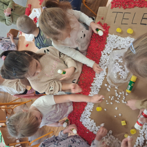 Dziecko wykleja angielska budkę telefoniczną kolorową bibułą