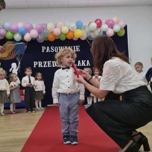 Pani Dyrektor pasuje dziecko na przedszkolaka.