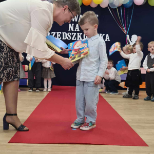 Pani Dyrektor pasuje dziecko na przedszkolaka.