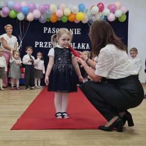 Pani Dyrektor pasuje dziecko na przedszkolaka.