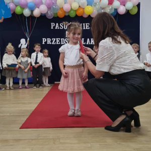 Pani Dyrektor pasuje dziecko na przedszkolaka.