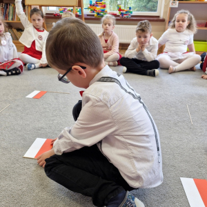 Chłopiec układa flagę Polski