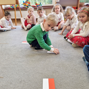 Chłopiec układa flagę Polski  