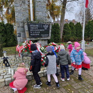 Dzieci kładą zapalone znicze przy Pomniku Ofiar Zbrodni Hitlerowskich w latach 1039-1945