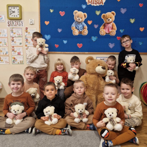 Chłopcy z misiami na tle dekoracji związanej  Dniem Pluszowego Misia